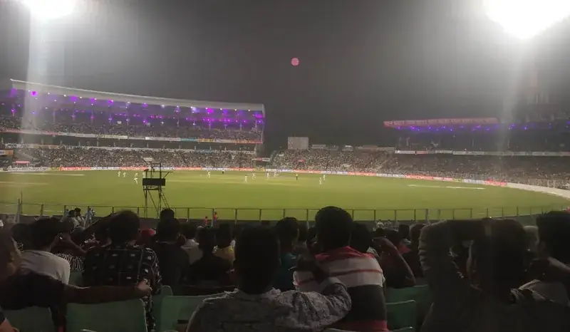 A packed Eden Gardens under floodlights during a day-night Test match.